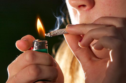 This is a picture of an adolescent burning marijuana wrapped in paper and smoking this, the structure being used to smoking is called a joint.